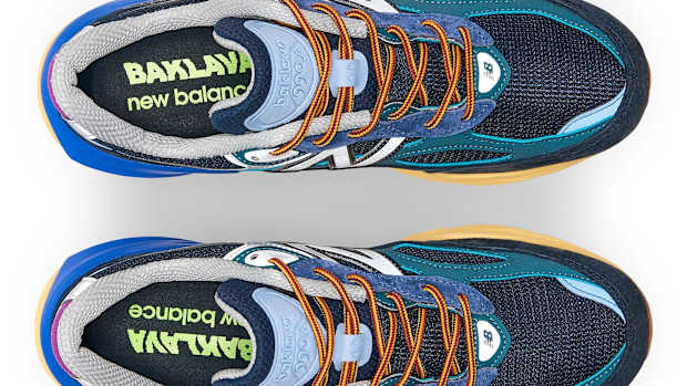 View of blue and orange New Balance shoes.
